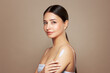 © Oleg Gekman - Cropped shot of a young tanned woman moisturizing her shoulder with her hand using a cream isolated on a beige background. Skin care. A white thick spear of cream on the female body