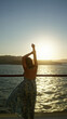 © Krakenimages.com - Woman on cruise deck with bare back stretching by the rail at golden sunset over the sea; calm reflection.