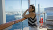 © Krakenimages.com - Woman leaning on ship rail with hand on cheek, smiling and looking up toward sea on cruise deck; serenity.