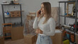 © Krakenimages.com - Young woman holding keys while talking on phone in new apartment surrounded by moving boxes suggests excitement and anticipation for new beginnings in a fresh living space.