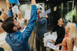 © qunica.com - Diverse team celebrates in an office, with arms raised and papers flying. A group of colleagues cheers in a bright, modern workplace.