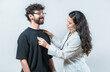 © IHERPHOTO - Female doctor checking male patient heartbeat with a stethoscope. Young Asian doctor checking a male patient heart with a stethoscope, isolated