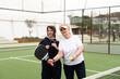 © Angelov - a girl teaches her grandmother how to play padel