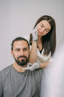 © Anna - Portrait of a young beautiful woman beautician in a medical white uniform and a young bearded man patient