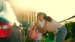 © Victoriia - Happy Mother hugs little girl getting ready for primary school lesson in schoolyard. Mom walks daughter school with backpack, hugging on street next to car. Family happiness. Childs education. Kid mom