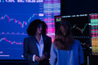 © Freeday photo - Women discuss stock market trends and data while monitoring cryptocurrency charts in a modern office setting