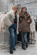 © Михаил Решетников - A mother and daughter are choosing a fur coat in a store.