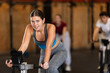 © JackF - Athletic woman in top and leggings at cycling training. Client of the gym at a group workout on an exercise bike