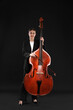 © New Africa - Girl with double bass and bow on black background