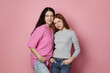 © New Africa - Portrait of mother and her teenage daughter posing on pink background