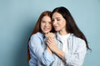 © New Africa - Mother and her smiling teenage daughter on light blue background. Space for text