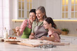 © New Africa - Smiling grandmother, her daughter and granddaughter cooking together at white marble table in kitchen
