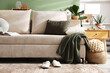 © New Africa - Slippers near stylish sofa with pillow and plaid at home