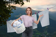 © New Africa - Happy woman with laundry basket in mountains