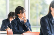© buritora - Elementary school students, junior high school students, high school students, and high school girls in uniforms listening seriously to a lesson in a school classroom (question, difficult, thinking, d