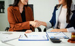 © laddawan - Woman lawyer hand and women client shaking hand collaborate on working agreements with contract documents