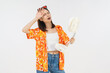© sitthiphong - Happy smiling young Asian woman in summer wearing floral shirt holding fan to cool herself with suffers from too hot weather in white background