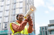 © Iryna - Person with megaphone speaks during a community event at a city construction site on a clear day