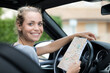 © auremar - happy woman holding map while sitting in car