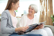 © auremar - elderly woman with her young granddaughter at family photo album