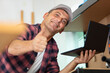 © auremar - mature engineer holding laptop and showing thumbs-up