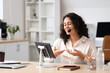 © Pixel-Shot - Female African-American online business consultant working with tablet computer at desk in office