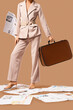 © Pixel-Shot - Young woman in high heels with many newspapers and suitcase on brown background, closeup
