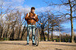 © Oscar - Young man using smartphone with bicycle in park