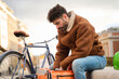 © Oscar - Courier checking delivery bag on city street