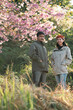 © chokniti - Couple in love enjoying nature travel, romantic relationship with happiness togetherness, smiling partners under blooming cherry blossoms, peaceful outdoor lifestyle