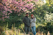 © chokniti - Couple in love enjoying nature travel, romantic relationship with happiness togetherness, smiling partners under blooming cherry blossoms, peaceful outdoor lifestyle