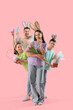 © Pixel-Shot - Happy family in bunny ears with Easter gifts on pink background