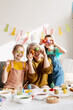 © Maria Vitkovska - Grandparent and grandchildren celebrating Easter, having fun with colorful dyed eggs