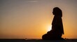 © amirhamzaaa - Woman Meditating on Beach at Sunset.