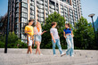 © deagreez - Group of young friends walking outdoors in a city after classes, enjoying a casual summer day with laughter and conversation