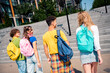 © deagreez - Group of young friends walking together outdoors with backpacks in a vibrant urban setting under natural daylight