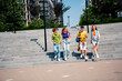 © deagreez - Group of young friends descending outdoor stairs in a vibrant city during a sunny day showcasing friendship and diversity