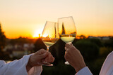 Couple toasts white wine sunset rooftop hotel bathrobe, romantic aperitif luxury celebration toast golden hour sunset romantic getaway