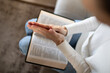 © kieferpix - Woman praying with hands together while reading Bible at home