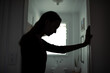© kieferpix - silhouette of tired woman leaning against wall in bathroom, stress and mental health concept