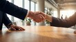 © Artem Zatsepilin - close up of business people shaking hands over wooden table in office. corporate partnership agreement or deal concept. successful meeting. banner, website header.