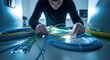 © Dece Std - Man works with bundle of fiber optic cables in cool blue light, tech setup