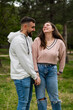 © pacoocimage - Happy couple holding hands laughing in green park