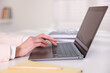 © New Africa - Woman working on laptop at white table indoors, closeup