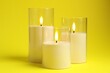 © New Africa - Beautiful LED candles on yellow background, closeup