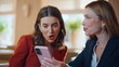 © stockbusters - Surprised friends looking mobile phone receiving great news in cafe closeup.
