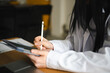 © Studio Marmellata - A person in a white shirt uses a stylus to write on a tablet, with papers and a laptop on the desk.