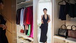 © stockbusters - Joyful woman trying dress admiring look wardrobe mirror. Fashion lady posing