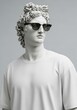 © Tiana_Geo - Male greek statue in modern t-shirt and sunglasses. Apollo bust with fashion accessory representing art, style and history concept.
