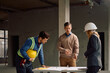 © Drazen - Building contractor talking about project plans with his team at construction site.
